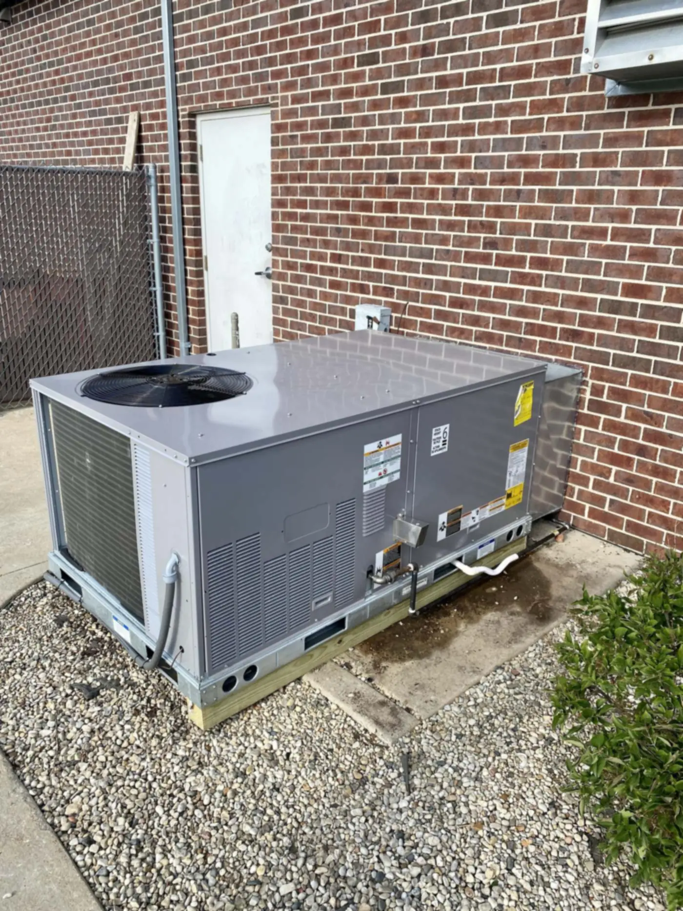 A new commercial rooftop unit set beside a brick building